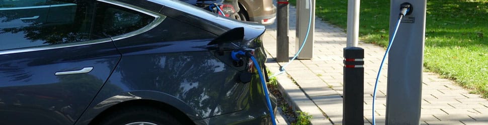 electric cars plugged in and charging on the street