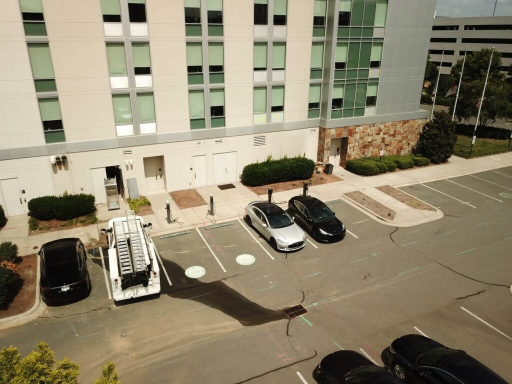 row of EV charging stations in a commercial building parking lot