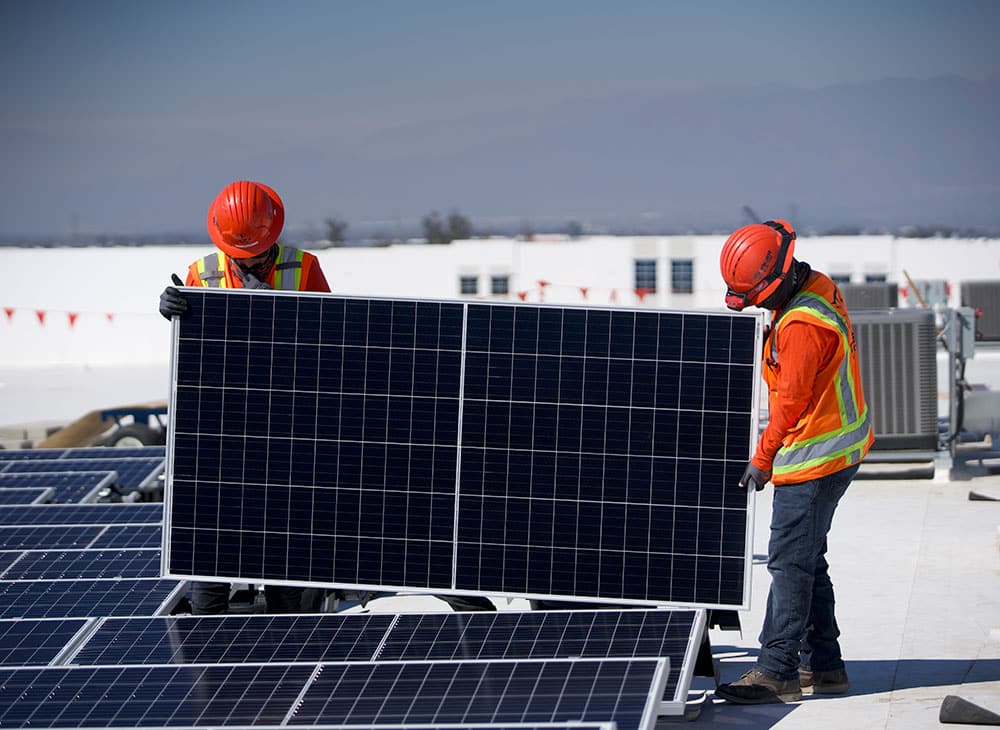 commercial solar installation of two electricians on a rooftop