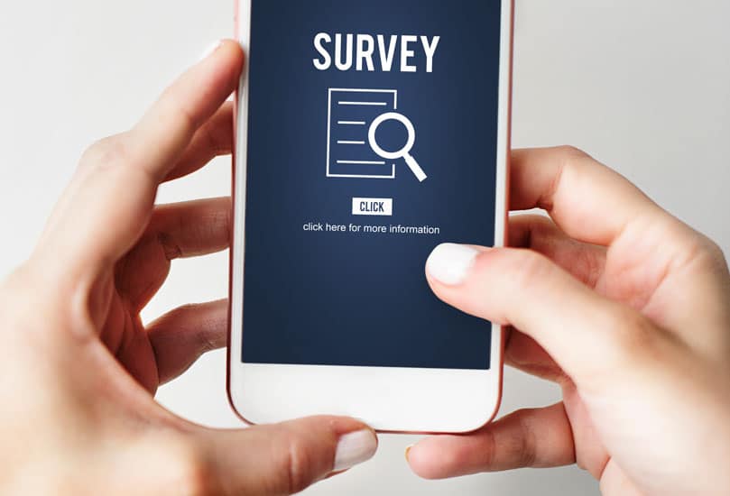 person holding a smart phone with a survey on screen